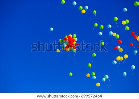 Group of multicolored helium filled balloons in the blue sky
