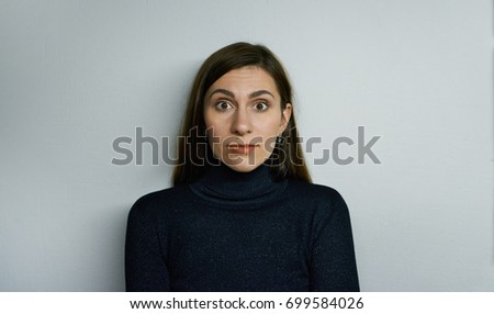 Picture of funny emotional bug-eyed brunette girl of European appearance looking at camera, having shocked amazed expression on her pretty face. Human emotions, feelings, reaction and attitude