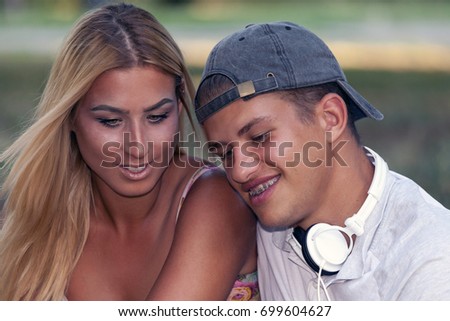 Smiling beautiful young couple in love having fun in park. They enjoy nature