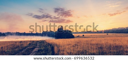 wonderful summer scenery.colorful sunrise over the lake and agriculture fields. unusual misty morning. dramatic scene. picturesque foggy nature landscape. creative image. instagram filter. retro style