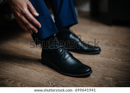 A man is wearing black shoes in close-up. Royalty-Free Stock Photo #699641941