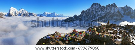 view from Gokyo Ri to Arakam Tse, Cholatse, Tabuche Peak, Thamserku and Kangtega with prayer flags - trek to Everest base camp - Nepal Royalty-Free Stock Photo #699679060