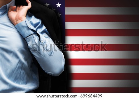 Man has a jacket on his shoulder on background as flag of USA. He end his job, work and going to relax. Labor day, united states of America
