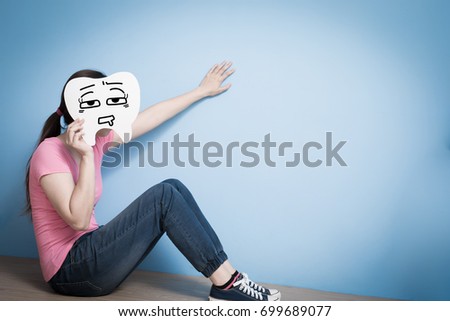 woman take tired tooth on blue background