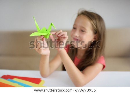 The girl puts origami from paper. lesson of origami Royalty-Free Stock Photo #699690955