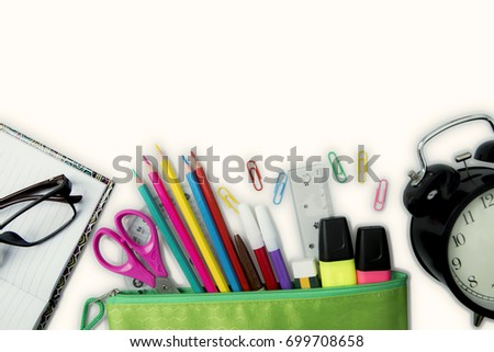 Top view of new school supplies with alarm clock, isolated on white background