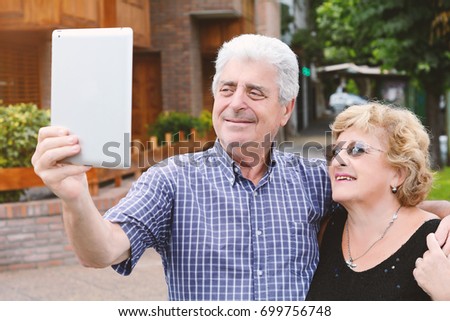 Portrait of an old couple taking selfie with digital tablet