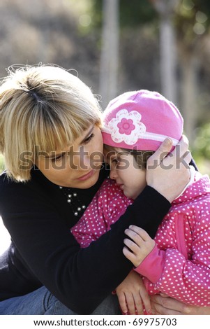 A picture of a mum comforting and hugging her baby girl in the park