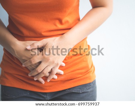 Young beautiful woman having painful stomachache.Chronic gastritis. Abdomen bloating concept. Royalty-Free Stock Photo #699759937