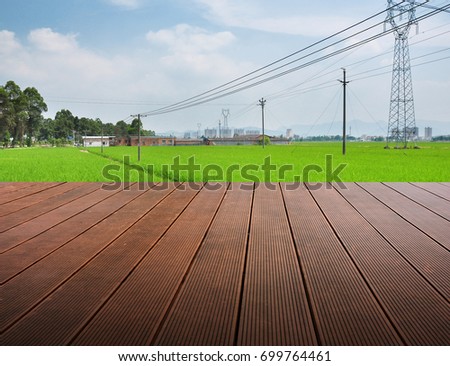 Synthesis of wooden planks floor and green field background. Green field under the sun. Wooden planks floor. Beauty nature background.