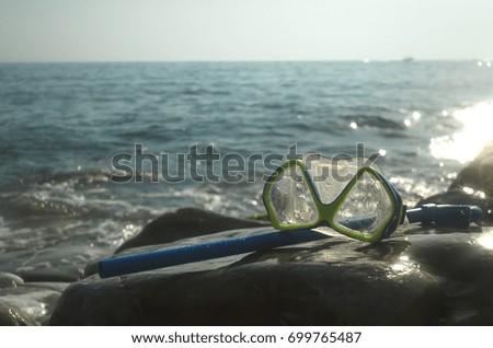Diving mask and snorkel on a rock on the sea coast. Diving concept or summer sea travel concept. Equipment for scuba diving.