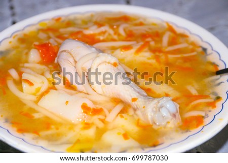 Boiled hip of a bird and pasta in a plate with chicken soup