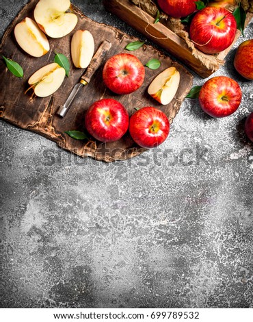 Red apples on a chopping Board with box. On rustic background.