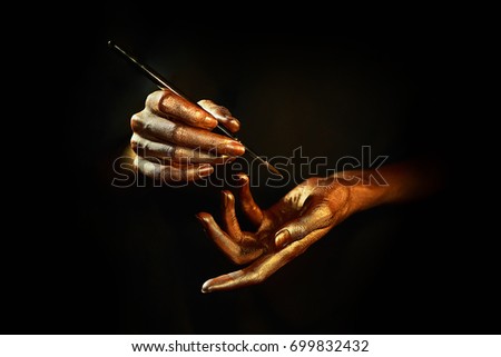 gold hands witn brush