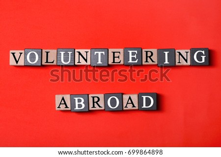 Volunteering concept. Wooden cubes on color background