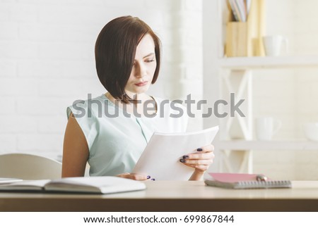 Pretty woman doing paperwork in modern office. Expertise and occupation concept 