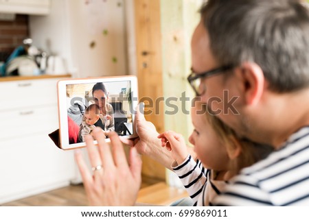 Young father videochatting with mother on tablet.