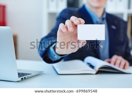 Businessman holding visit card. Man showing blank business card. Person in blue suit. Mock up design.