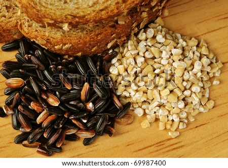 Whole grain goodness.  Close up image of whole wheat bread, steel cut oats, and black (mahogany) rice on wood cutting board.