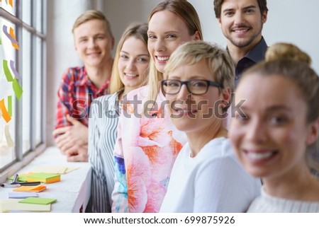 A portrait of six smiling, happy, cheerful office colleagues discussing ideas in a bright office meeting. Royalty-Free Stock Photo #699875926