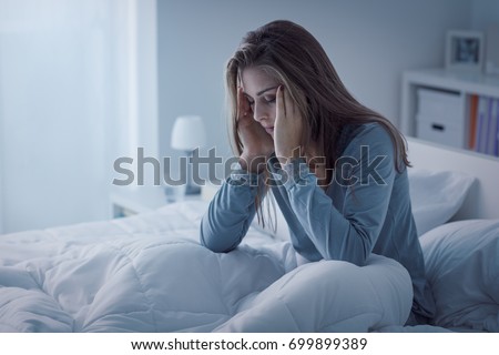 Depressed woman awake in the night, she is exhausted and suffering from insomnia Royalty-Free Stock Photo #699899389