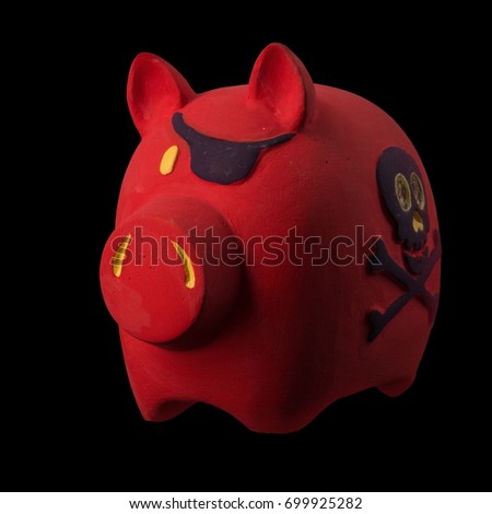 Red pig money box with a picture skull and bones on its side figurine on a black background