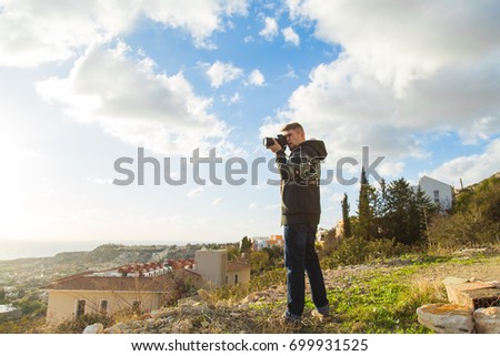 Travel, vacation, photographer and hitchhiker concept - traveler man photographed mountains and town
