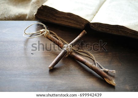 Ancient religious book and wooden cross on the background of a wooden and burlap
