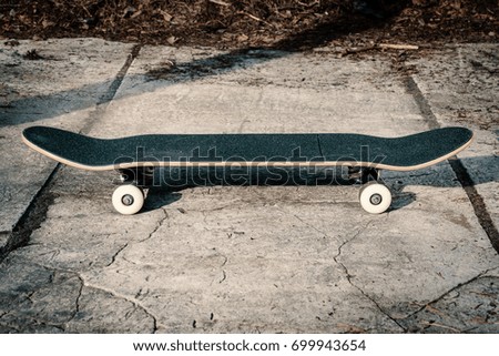 Black skateboard isolated on a concrete background in skate park