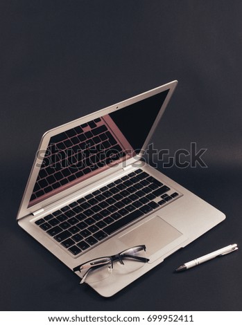 Modern laptop computer on dark background. The concept of work in the office.