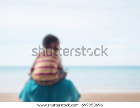 The boy on shoulder of father with a blurred image.