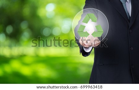 business man finger pointing at paper green recycle symbol with nature background, environment concept.