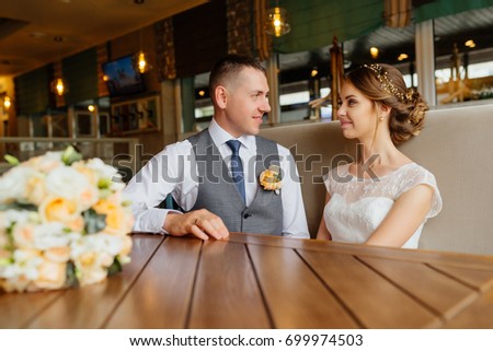 Luxury stylish wedding. Wedding day. Beautiful bride and elegant groom look at each other. Luxury bridal dress and bouquet of flowers. Bride and groom at wedding day