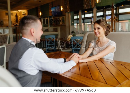 Elegant stylish wedding. Bride and groom after wedding ceremony sitting at the table and look at each other and smiling. Happiness concept