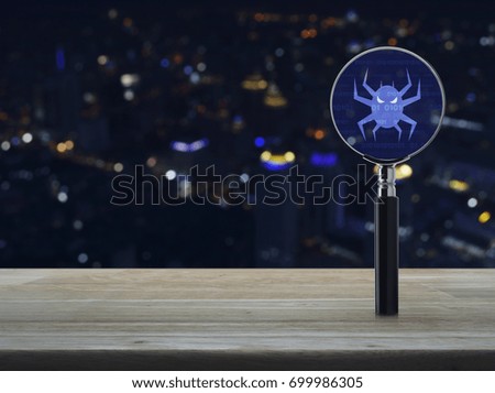 Virus computer icon with magnifying glass on wooden table over blur colorful night light city tower background, Business internet security concept