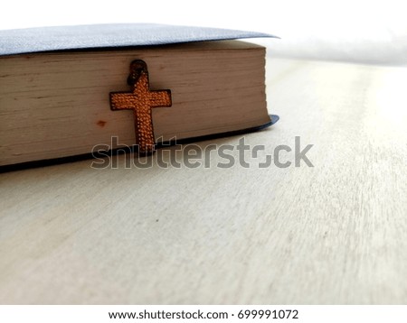 Christian Cross with old book on wooden floor, copy space