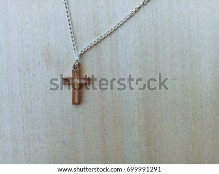 Christian Cross necklace on wooden background with copy space