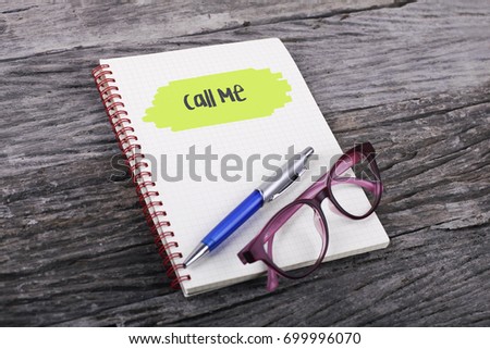 Note with call me on the wooden background