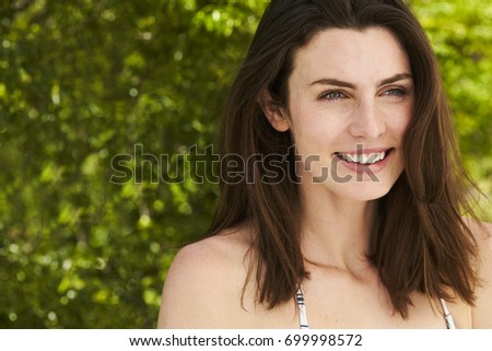 Beautiful brunette looking away and smiling, close up 