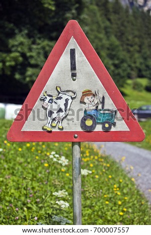 Triangular red and white road sign advising Beware of Cattle on the road. Switzerland