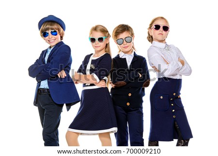Group of modern children posing in school uniform and sunglasses. School fashion. Isolated over white background.