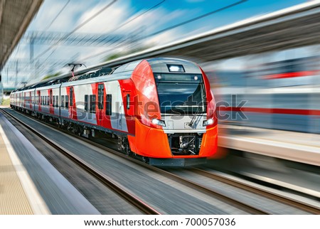Modern high-speed train moves fast along the platform. Royalty-Free Stock Photo #700057036