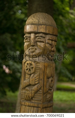 A figure from a log, a face carved into a tree