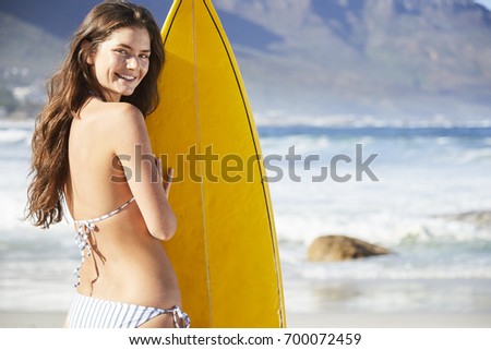 Bikini babe with surfboard on beach, portrait