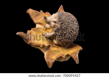Plaster figurine hedgehog on a black background
