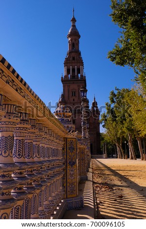 View from one of the towers of the Plaza de Espana in Seville (Spain) with blue sky and green trees in the background and railing in the foreground