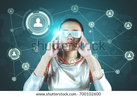 Picture of Asian woman using futuristic glasses for looking at social network icons