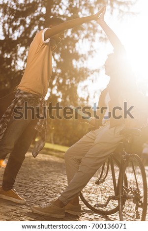 young students making high five in park