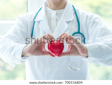 Cardiologist doctor holding red heart in clinic hospital exam room office for professional medical cardiology health care service, csr donation charity organ donor and world heart health day concept Royalty-Free Stock Photo #700156804