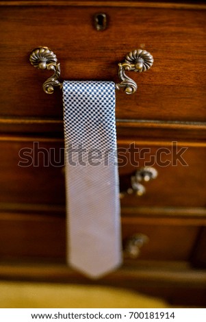 A blue tie on a drawer handle. 